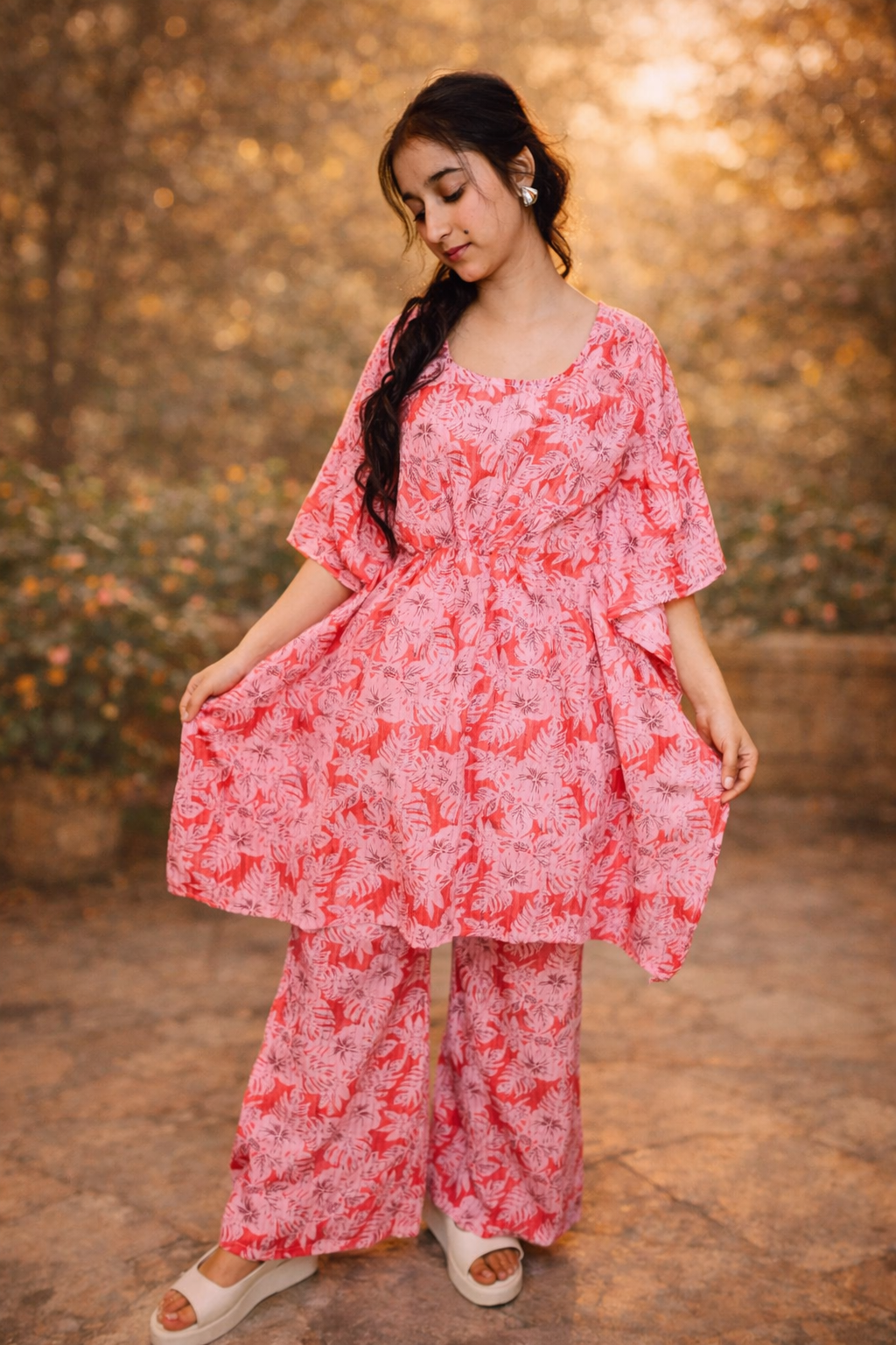 Woman wearing a pink floral outfit against a warm-toned background